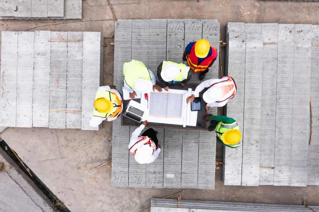 Engineers reviewing construction plans on site to support infrastructure investment and project planning.