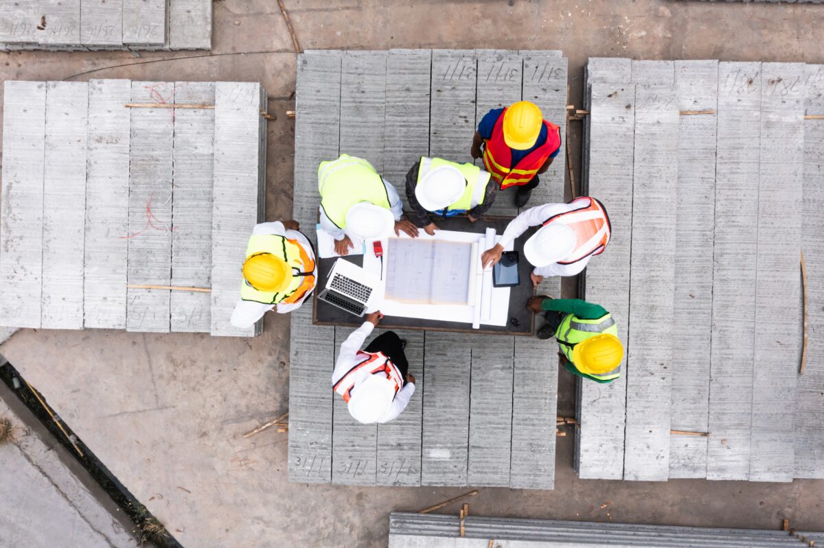 Engineers reviewing construction plans on site to support infrastructure investment and project planning.